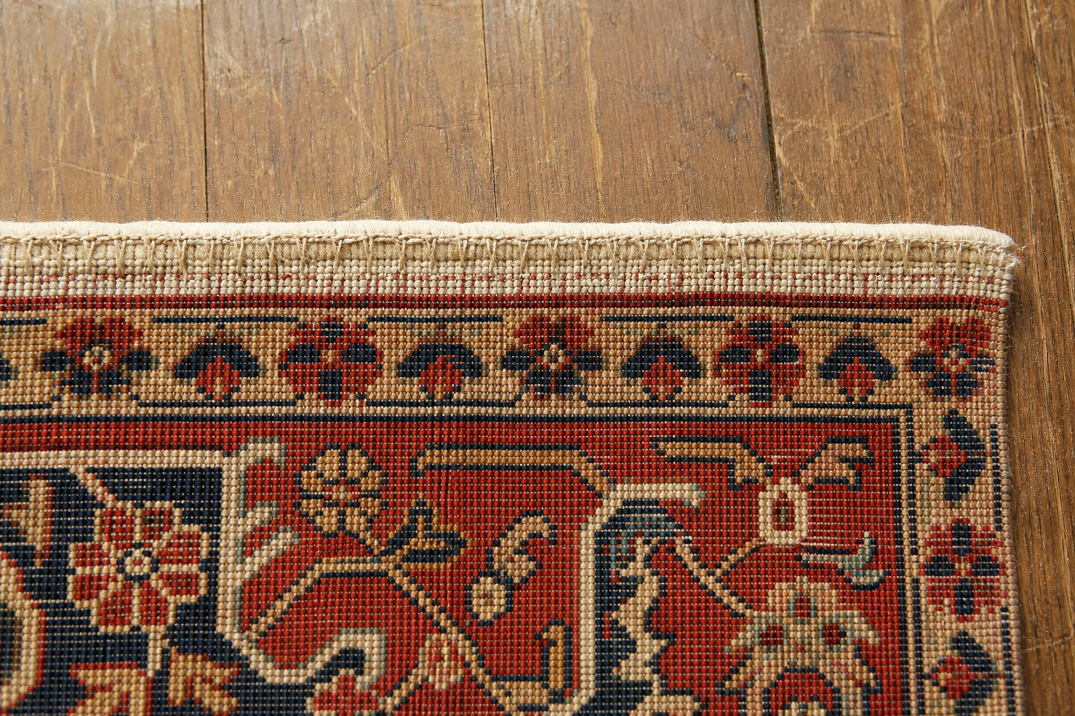 The end of a rug secured with a neat hand-sewn end-stop to stop unraveling